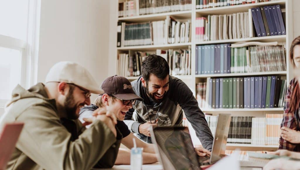 a group of men looking at a laptop