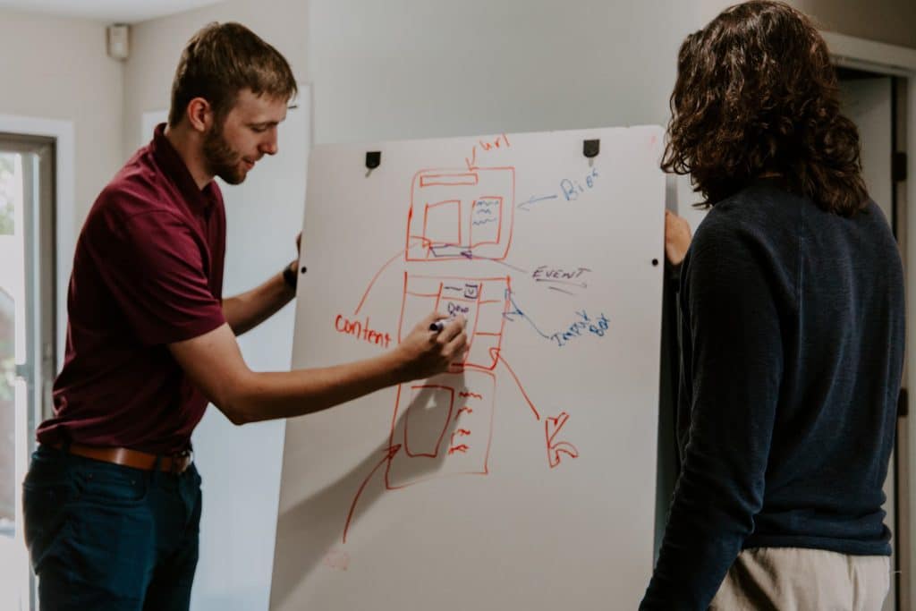 a man writing on a whiteboard