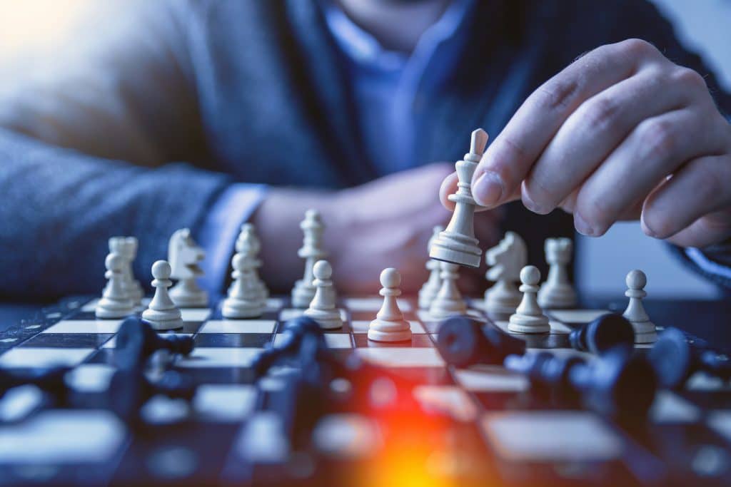 a person playing chess with a white piece